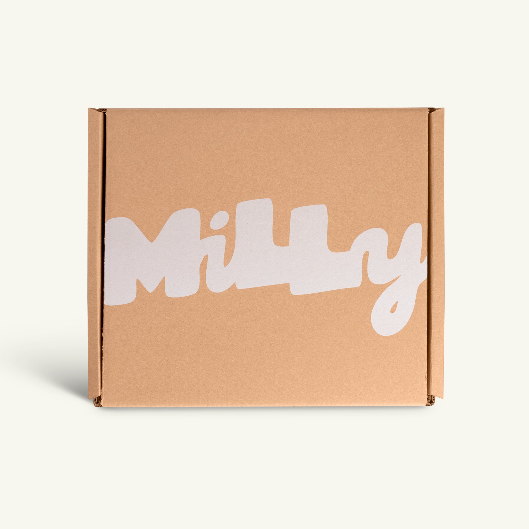 Closed kraft Milly shipping box with the Milly logo in white bubbly lettering on the front, photographed against a clean off-white background.
