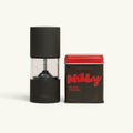 A matte black Milly pepper grinder standing next to a dark tin with a bright red lid labeled Milly Black Pepper, both on a clean off-white background.