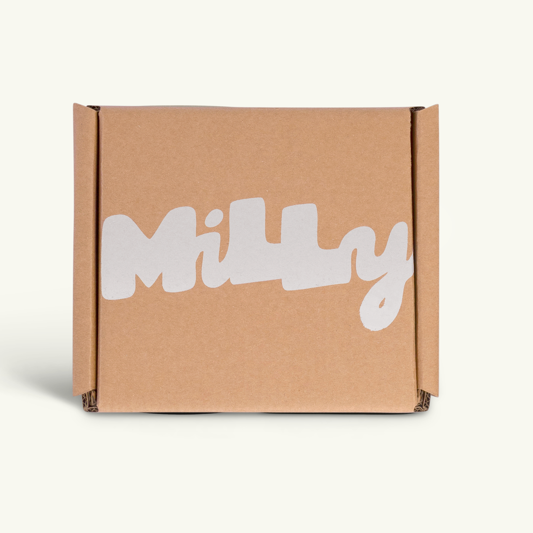 Closed kraft brown Milly shipping box with the Milly logo printed in white on the front, photographed against a clean off-white background.